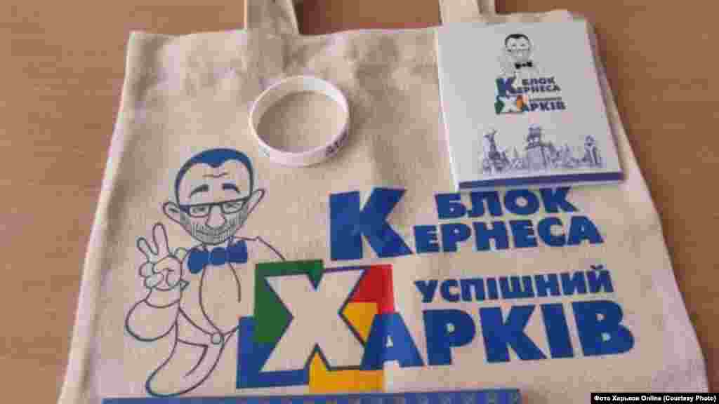 Де? Харків. Що роздають? Подарунки для школярів. Від кого? Геннадій Кернес, мер Харкова.  Деталі: 1 вересня в харківських школах безкоштовно розповсюджували набори для учнів із символікою партії чинного мера «Блок Кернеса – Успішний Харків». Серед вмісту пакетів, зокрема, можна було знайти блокноти, браслети, календарики, захисні маски.  При цьому, як сказали в Департаменті освіти Харківської міськради, це не була політична реклама: «Коли дитина одержала подарунок і взяла його додому, то це не є політична реклама. Кернес успішний мер успішного міста. Чому б йому не передати школярам сувеніри?»