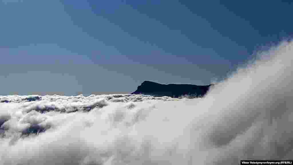 В гуще облаков можно разглядеть вершину Чатыр-Даг. К слову, на Демерджи можно наблюдать такой природный феномен как Брокенский призрак. Его еще называют «горным призраком». Это тень наблюдателя на поверхности облаков в направлении, противоположному Солнцу. Тень может быть окружена цветными кольцами. По сути это ‒ оптическая иллюзия