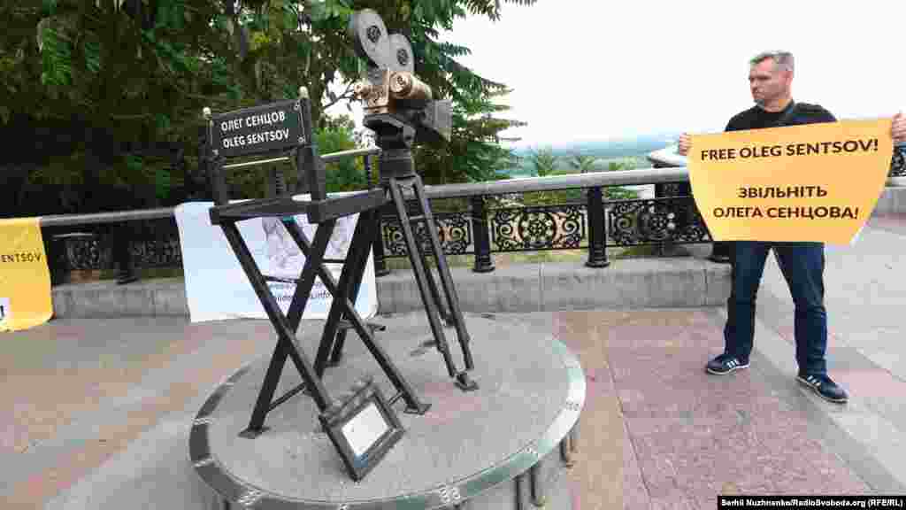 «На этом месте мы не просто так. Это известная композиция – кинокамера с пустым режиссерским креслом. Это место для Олега Сенцова. Но сегодня он, к сожалению, не с нами. Мы надеемся, что следующий день рождения мы будем встречать вместе с ним», – отметил один из организаторов акции Максим Буткевич.