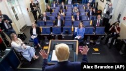 Američki predsednik Donald Tramp (s leđa) na konferenciji za novinare u Beloj kući, ispred predstavnika sedme sile koji su i sami na fizičkoj distanci propisanoj kao mera prevencije širenja korona virusa. 6. april 2020.