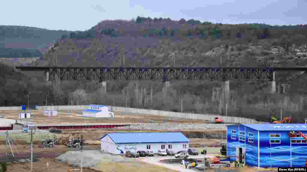 Железнодорожный мост, соединяющий два борта Камышловской балки, расположен рядом с территорией строительства водозабора. Здание в углу площадки, ближе всего к мосту, – это насосная станция первого подъема, которая производит забор воды из накопительного бассейна (ковша)