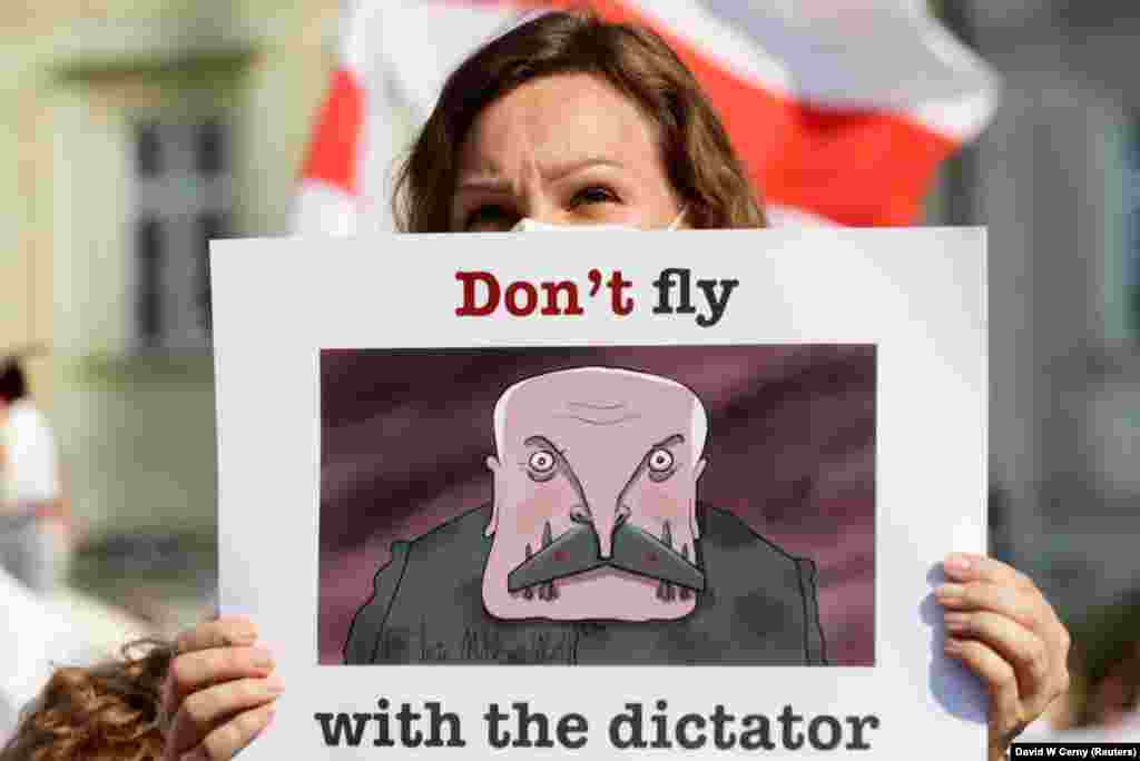 Учасниця акції солідарності тримає у руках плакат з написом: «Не літайте з диктатором»