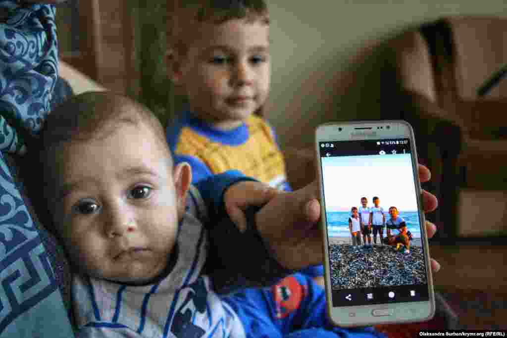 Сыновья арестованного музыканта Эрфана Османова – фигуранта второго симферопольского «дела Хизб ут-Тахрир». Младший сын Камаль держит за руку маму, которая показывает их семейную фотографию. Всего в семье Османовых четверо детей