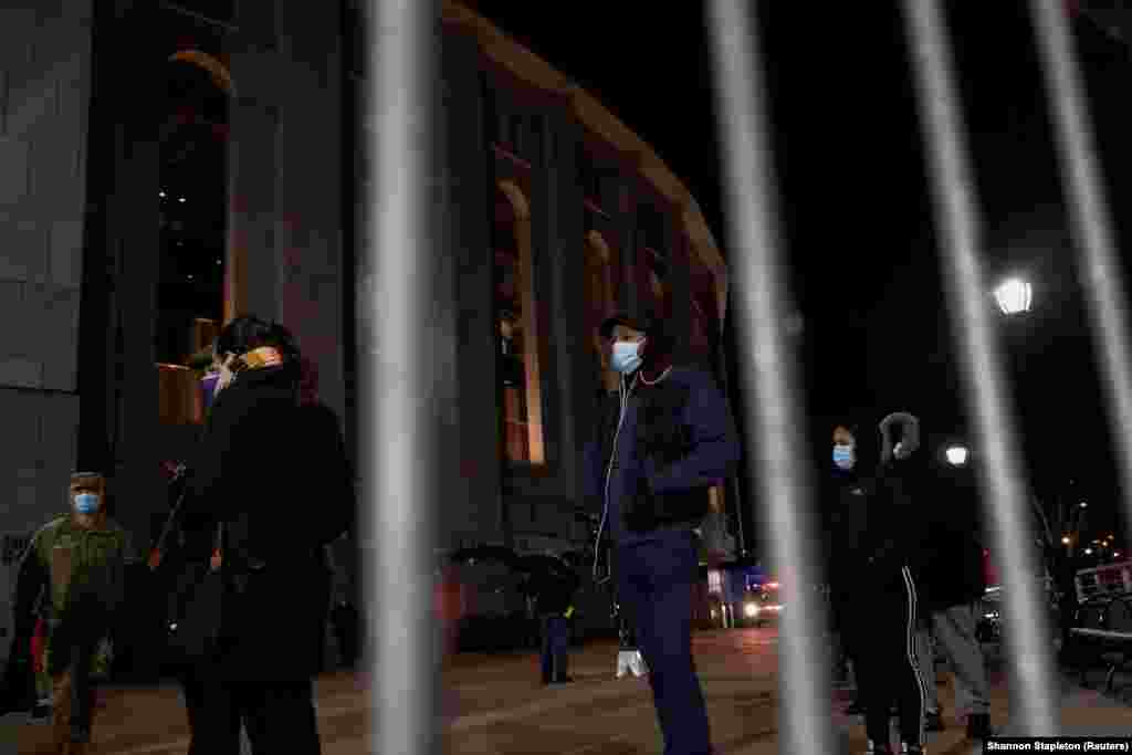 Люди в захисних масках чекають у черзі, щоб отримати вакцину від коронавірусної хвороби Johnson & Johnson на стадіоні Янкі в районі Бронкс в Нью-Йорку, США