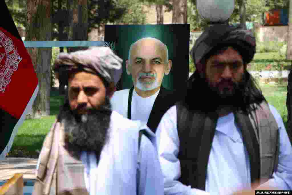 Колишні в'язні-таліби стоять на тлі портрету президента Афганістану Ашрафа Гані під час процедури звільнення їх урядом. Герат, 26 травня 2020 року