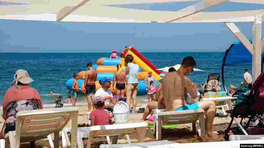 Посетители пляжа «Учкуевка» прячутся от солнца под навесами