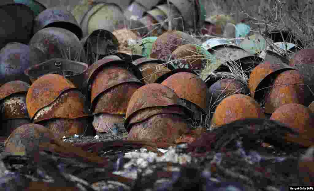 Іржаві пошкоджені армійські каски купою лежать на дорозі передмістя Степанакерта (Ханкенді)