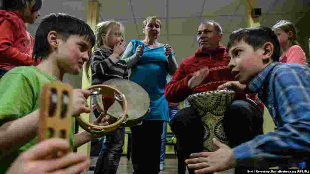 Діти та куратори б'ють у барабани, намагаючись викликати сонячну погоду на завтрашній день