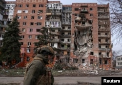 Український солдат проходить повз житловий будинок, пошкоджений російськими військовими ударами у прифронтовому місті Покровськ, 6 березня 2025 року