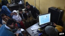 پاکستان کې يوه افغانه کورنۍ له يو اېن اېچ سي ار سره خپل راجسټرېشن کوي ــ انځور له ارشيفه