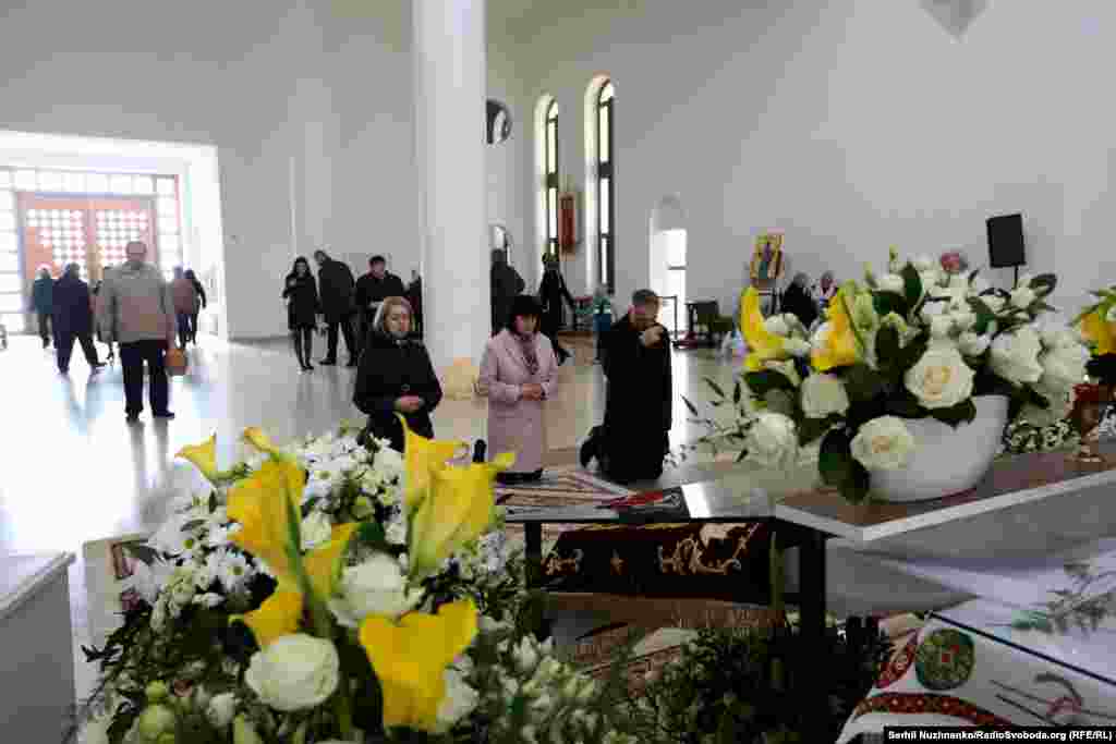 Віряни припадають на коліна перед плащаницею 