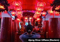 Віряни використовують святкові аромапалички у храмі в Джакарті, Індонезія, 11 лютого 2021 року