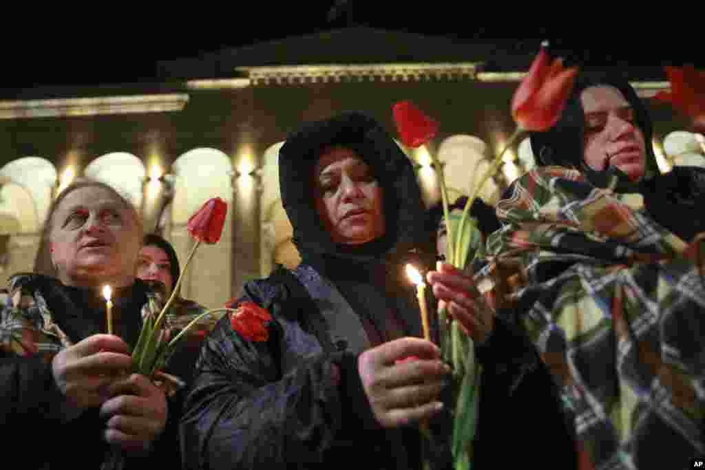 Грузины зажигают свечи в память о "Тбилисской трагедии", когда двадцать человек были убиты в этот день в апреле 1989 года во время антисоветской демонстрации, а также в честь Дня единства у здания парламента Грузии в центре Тбилиси. 9 апреля 2025 года. AP Photo/Zurab Tsertsvadze