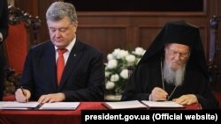 Президент України Петро Порошенко та Вселенський патріарх Варфоломій I під час підписання угоди про Співробітництво і взаємодію