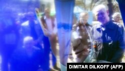 Отображение людей на экране телевизора во время трансляции выступления президента России Владимира Путина (архивное фото)