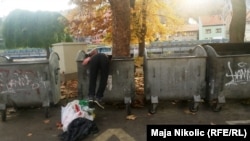Mulți dintre oamenii străzii se hrănesc cu ceea ce aruncă alții. În imagine, un bărbat din Kîrghistan care scotocește într-o pubelă pentru a găsi de-ale gurii