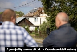 Польські селяни дивляться на зруйнований дроном дах будинку в селі в ґміні (районі) Вирикі у східній Польщі. 10 вересня 2025 року