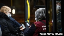 Кондуктор во время проверки QR-кодов у пассажиров в автобусе