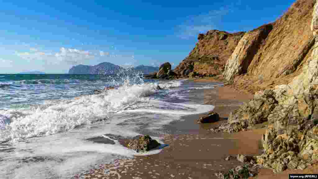 Коктебельский залив с востока ограничивается мысом Киик-Атлама, с юго-запада – Планерным (Мальчин, Пастуший), который в свою очередь представляет собой восточный склон массива Кара-Даг. На первом мысе раскинулся закрытый в советское время из-за работающих там двух военных заводов поселок городского типа Орджоникидзе, у мыса Планерный – популярный курортный поселок Коктебель. Коктебельский залив включает в себя четыре бухты: Коктебель, Мертвую, Тихую и Провато. На фото – скалистый берег бухты Провато, где с запада заканчивается пляжная зона поселка Орджоникидзе