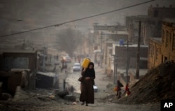 Žena nosi vodu u kanisteru dok se penje uzbrdo na putu prema svojoj kući u Kabulu (fotoarhiv)