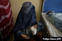 A woman holds one of her two babies undergoing treatment at the malnutrition ward at Indira Gandhi Children's Hospital in Kabul on October 5.