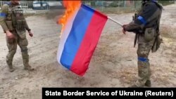 Українські військовослужбовці спалюють російський прапор у звільненому від армії РФ місті Вовчанську (Харківщина), що розташоване на кордоні з Росію. Кадр з відео, що було оприлюднене 13 вересня 2022 року