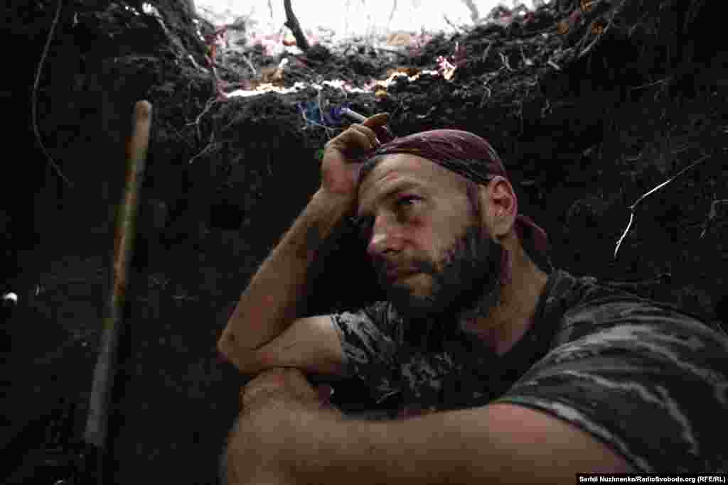 Український військовий на ім’я Денис на Донеччині перечікує російський обстріл на позиції неподалік Яковлівки. 29 серпня 2022 року. У мирному житті він – археолог і викладач. Денис із Миколаєва. Він каже: «В Україну прийшли люди зі зброєю, хочуть нав'язати свою думку, свої правила. І так не робиться в цивілізованому світі. За нами наші міста, наші будинки, наші родини. Тому ми тут… Ми вже не будемо наступати на ті самі історичні граблі, я сподіваюся, вкотре. Ми обов’язково відбудуємо, всі будемо процвітати, будемо квітучою країною, де кожен буде пишатись тим, що він українець»