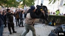 Участник в протеста хвърля чувал с боклук пред сградата на "ДПС - Ново начало".