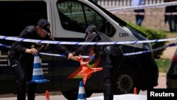 Španski policajci rade u blizini tijela Andrija Portnova, ukrajinskog advokata kojeg su neidentifikovani napadači upucali ispred škole u Madridu 21. maja.