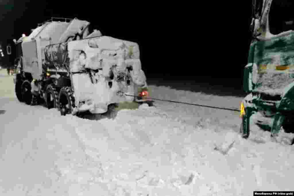 Автомобиль отряда подразделений армейского корпуса Черноморского флота России оказывает помощь по эвакуации застрявшего в снегу грузовика на трассе «Таврида»