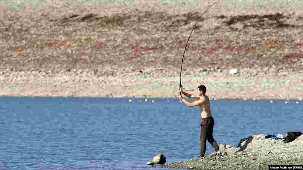 Мужчина ловит рыбу на Симферопольском водохранилище