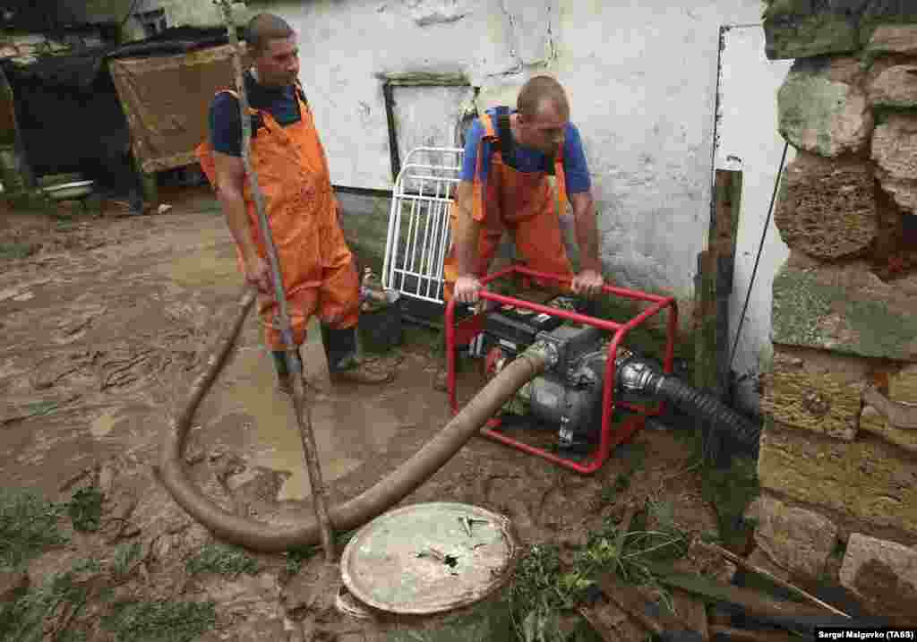 Сотрудники «Крым-Спас» откачивают воду во дворе затопленного дома в селе Красногорка Ленинского района