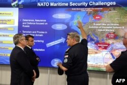 Președintele francez Emmanuel Macron și prim-ministrul Marii Britanii, Keir Starmer, ascultă un ofițer militar NATO în timpul unei întâlniri a Coaliției Voluntarilor la o bază militară de la sediul Northwood din nord-vestul Londrei - 10 iulie 2025.