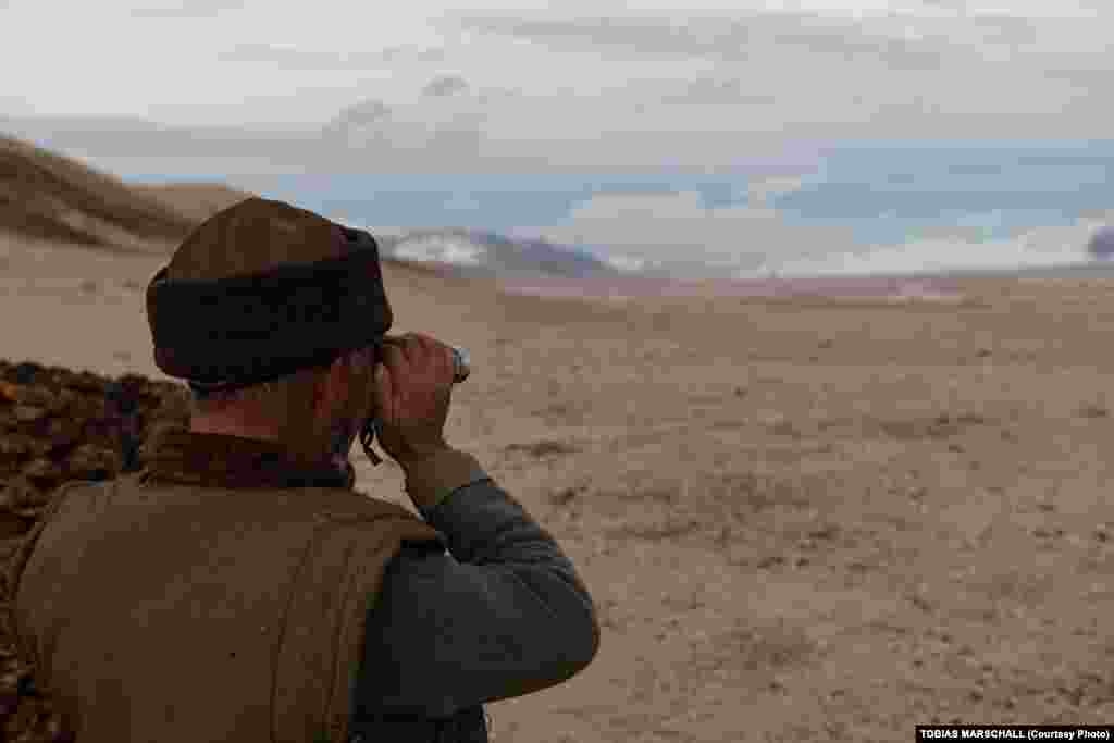 At the end of the day, a Pamir Kyrgyz herder uses binoculars to see if any of his livestock were left behind on the way home from pasturing.