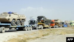 Pakistani drivers guide trailers carrying armored vehicles for NATO forces near Quetta. (file photo)