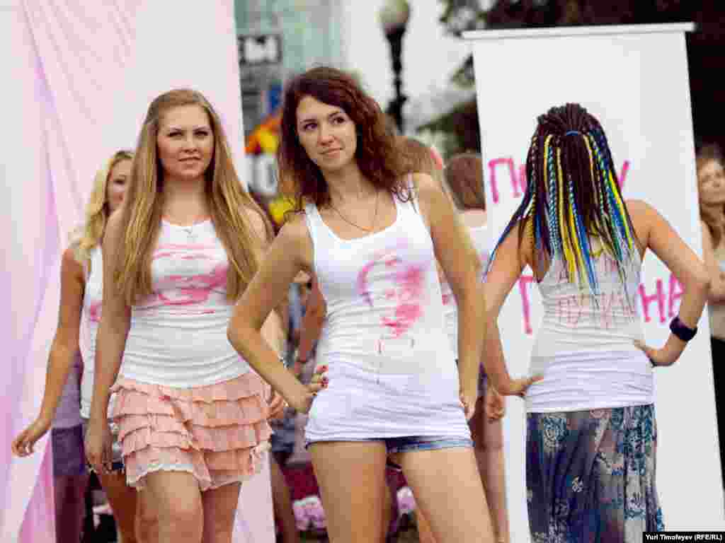 Надев разрисованные майки, девушки выстроились перед журналистами и начали скандировать "Путин! Путин!", ходить кругами и посылать воздушные поцелуи.