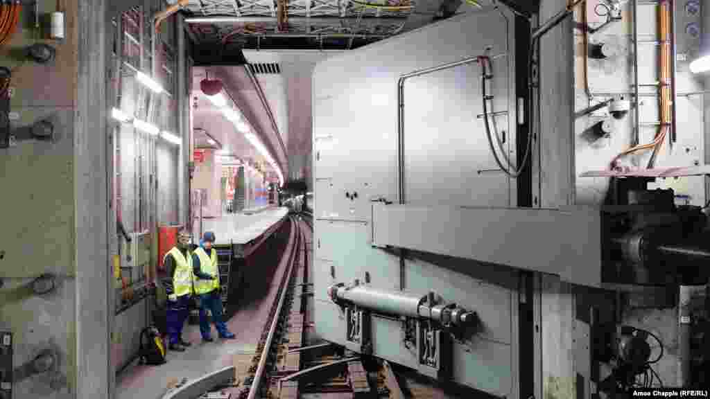 Inženjeri posmatraju kako se preko šina podzemne željeznice hermetički zatvaraju blindirana vrata. OSM je ugrađen u mrežu praške podzemne željeznice početkom 1974. godine, kada je strah od nuklearnog rata vladao Evropom.  