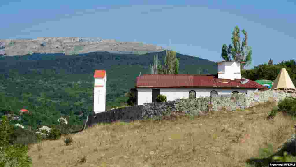 Церковь преподобного Афанасия Печерского возвышается над Романовским шоссе, которое ведет в монастырь Косьми и Дамиана на территории Крымского природного заповедника. На дальнем плане – южный край Чатыр-Дага, село Изобильное Больше фото – здесь 