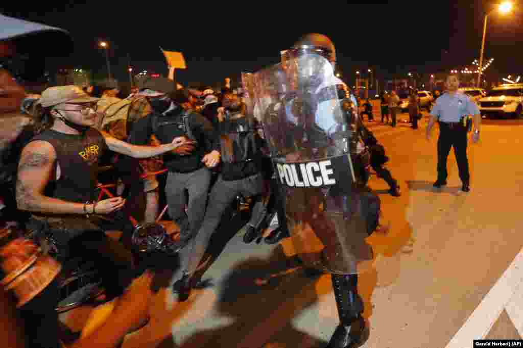 Протестувальники намагаються прорватися через шеренгу поліцейських на мості Crescent City Connection, який пролягає через річку Міссісіпі в Новому Орлеані, під час протесту, пов'язаному зі смертю Джорджа Флойда. Новий Орлеан, штат Луїзіана, 3 травня 2020 року (Фото AP/Gerald Herbert)