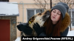 Айгуль со стерилизованной и привитой собакой, в ухе которой можно заметить жёлтую клипсу.