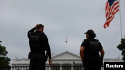 Polițiști la datorie în fața Casei Albe din Washington în zorii zilei în care V. Zelenski va fi primt de D. Trump.
