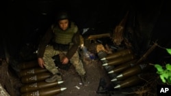 Військовослужбовець 59-ї окремої мотопіхотної бригади ЗСУ сидить біля артилерійських боєприпасів на позиції на Авдіївському напрямку, Україна, 6 травня 2024 року