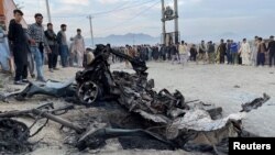 People stand at the site of a deadly bomb blast in Kabul on May 8.