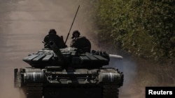 Українські військовослужбовці їдуть на танку по дорозі до прифронтового міста Бахмут, травень 2023 року