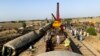 Workers clear the wreckage from a railroad track in Sindh Province on June 8, a day after a packed inter-city train ploughed into another express train that had derailed.