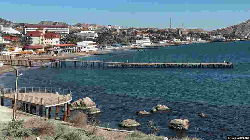 Причал в море с восточной стороны Генуэзской крепости, просевший в феврале 2016 года. В ходе ремонта между уцелевшими частями причала соорудили мостовой переход