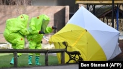 Members of the emergency services in biohazard suits place a tent over the bench where Sergei Skripal and his daughter Yulia were found unconscious after being exposed to what Britain says was the nerve agent Novichok in Salisbury, England, on March 4.