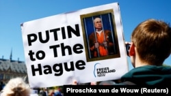 Протестувальники біля будівлі Міжнародного суду вимагають арешту російського лідера Володимира Путіна. Гаага, Нідерланди, 7 травня 2024 року