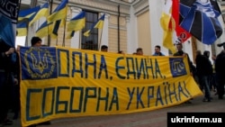 Участники марша ультрас, футбольных болельщиков и представителей патриотических организаций держат полотно с надписью "Одна, единая, соборная Украина", Одесса, 5 марта 2016 года.