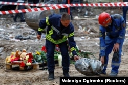 Spasioci nose fragment ruske krstareće rakete Iskander-K koja je pogodila stambenu zgradu u Kijevu 1. avgusta.